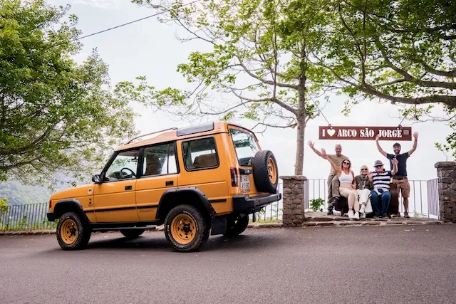 Family with guide at a viewpoint, jeep behind